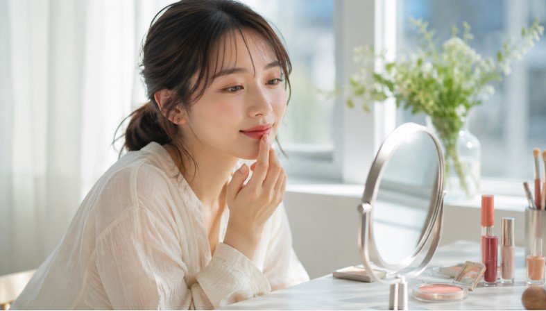 リップモンスターのラスボスを指でぼかして自然な発色に調整する日本人女性